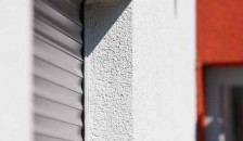 Alulux Aluminium Rollladen auf weiß-roter Hausfassade in Nahaufnahme