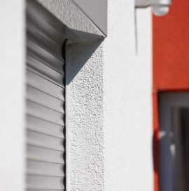 Alulux Aluminium Rollladen auf weiß-roter Hausfassade in Nahaufnahme