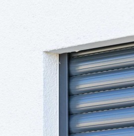 Aufsatzrollladen an weißer Hausfassade in der Nahaufnahme