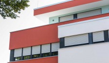 Alulux Aluminium Aufsatzrollladen an roter Hausfassade